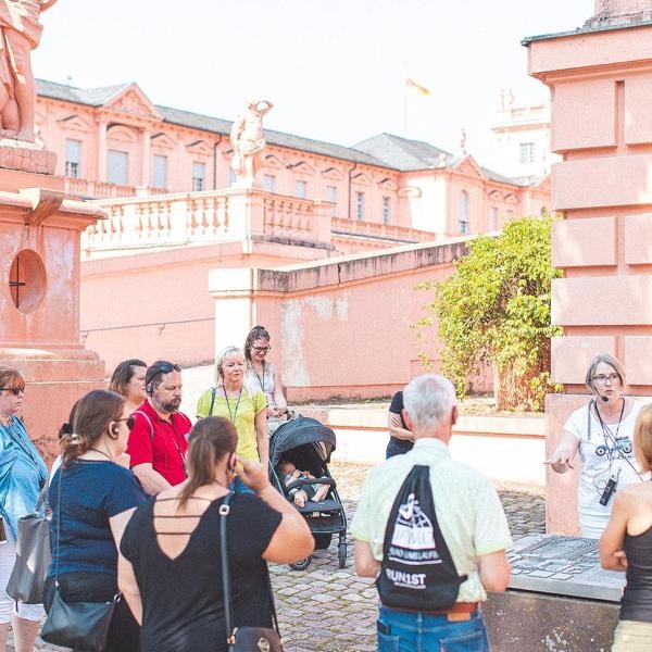 Touristen bei einer Stadtführung vor dem Schloss in Rastatt