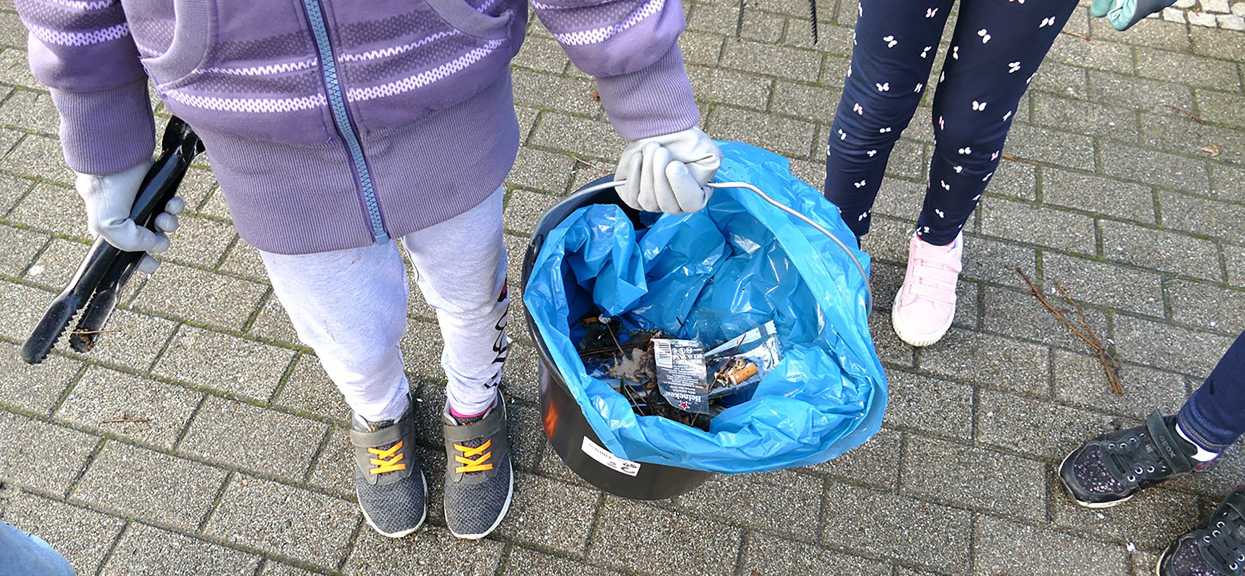 Mädchen hält Abfalleimer in der Hand