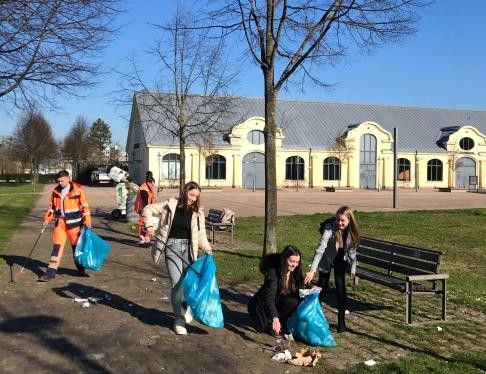 Jugendliche sammeln in einem Park Müll ein