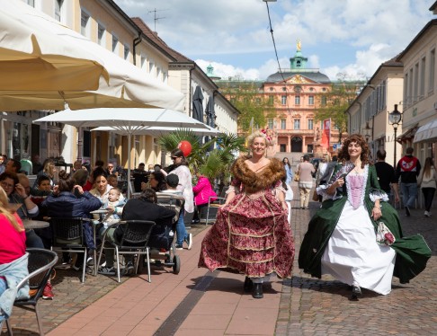 Zwei Frauen laufen verkleidet wie Hofdamen durch die Rastatter Innenstadt.