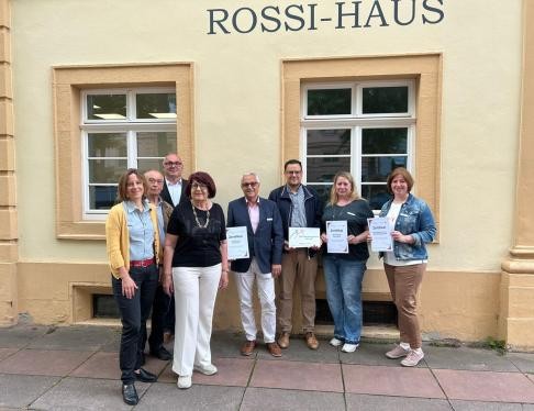 Personen mit Urkunde in der Hand
