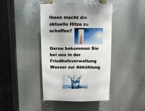 Hinweisschild auf dem Stadt- und Waldfriedhof weist auf Trinkwasserausgabe an heißen Tagen hin.