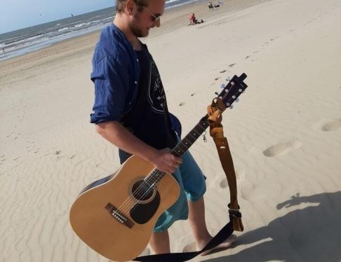 Mann am Strand mit Gitarre in der Hand
