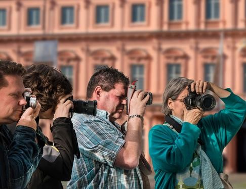 Viele Menschen mit einer Fotokamera vor dem Gesicht, im Hintergrund das Rastatter Residenzschloss.
