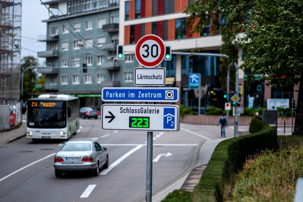 Rue avec galerie du château et panneaux de signalisation