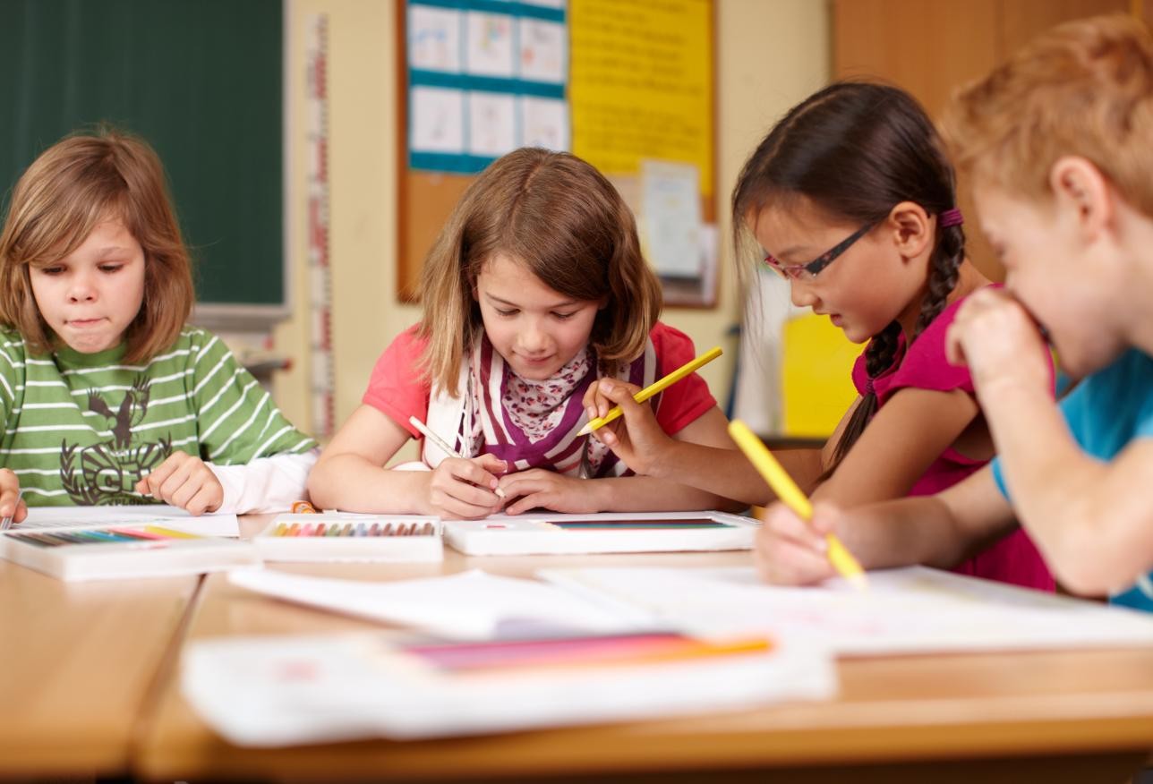 Group of 4 children sitting and working at the table