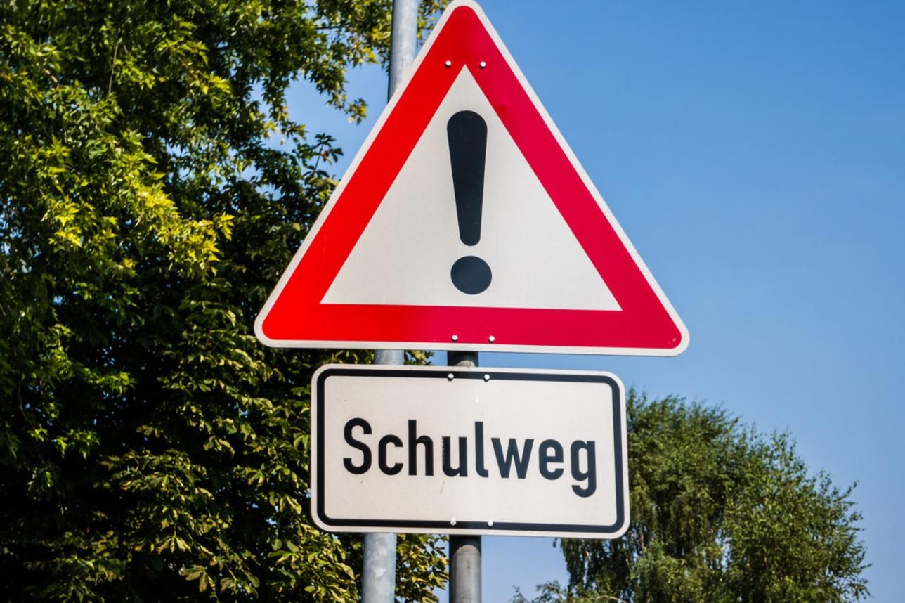 Verkehrszeichen "Allgemeine Gefahrenstelle" und Schulweg