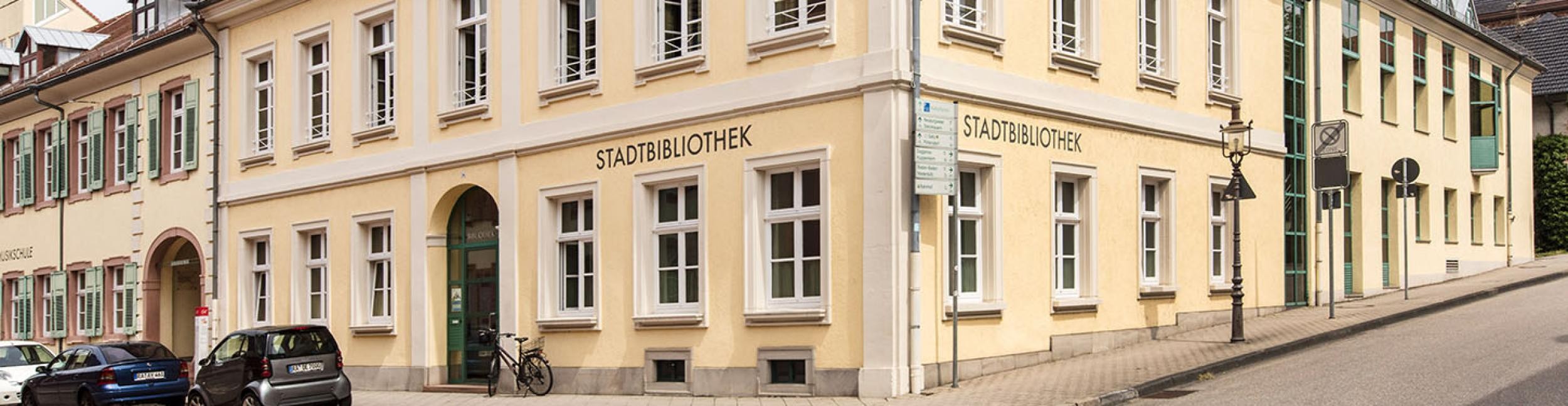 Stadtbibliothek Außenaufnahme mit Kreuzung, Autos parken an der Straße.