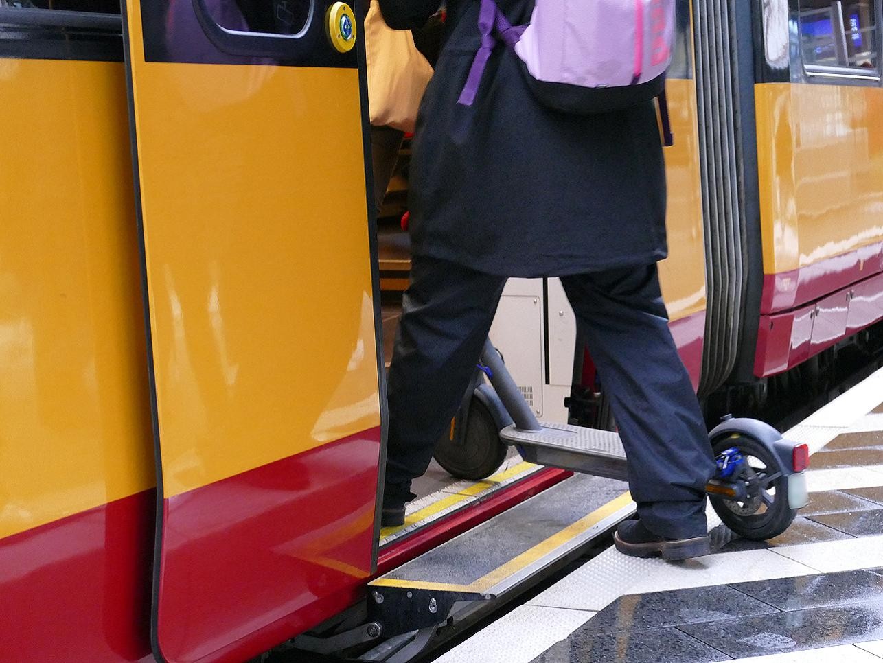 Eine Frau steigt in eine barrierefreie Straßenbahn ein