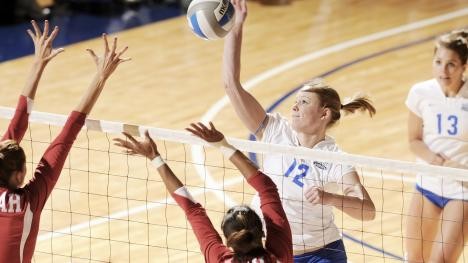 Women's volleyball: player hits ball over the net