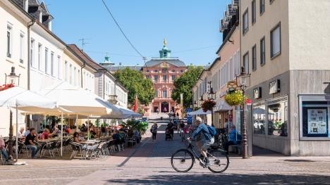 Schlossstraße in Rastatt mit Menschen im Café und einem Fahrradfahrer