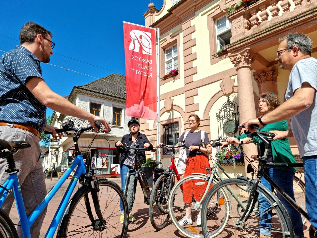 Gruppe von Radfahrern steht vor dem Historischen Rathaus und bespricht die Route