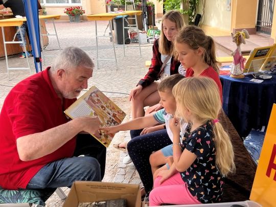 Kinderbuchautor Hans Peter Faller ließt Kindern aus einem Buch vor