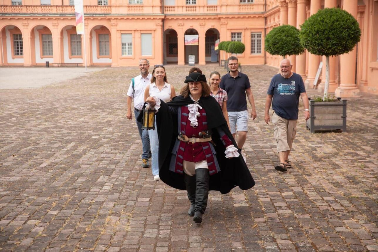 Mann im historischen Kostüm bei einer Führung im Schlosshof