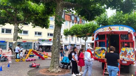 Enfants jouant sur la place du marché près du Spielmobil