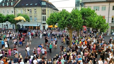 Des gens qui dansent sur la place du marché de Rastatt lors de la danse sous les platanes