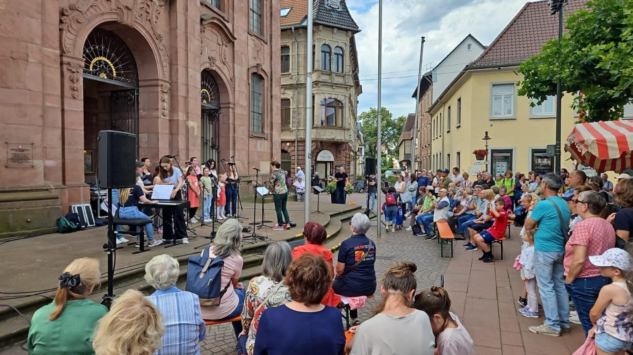 Ein Kinderchor und Zuschauer vor der Rastatter Stadtkirche St. Alexander