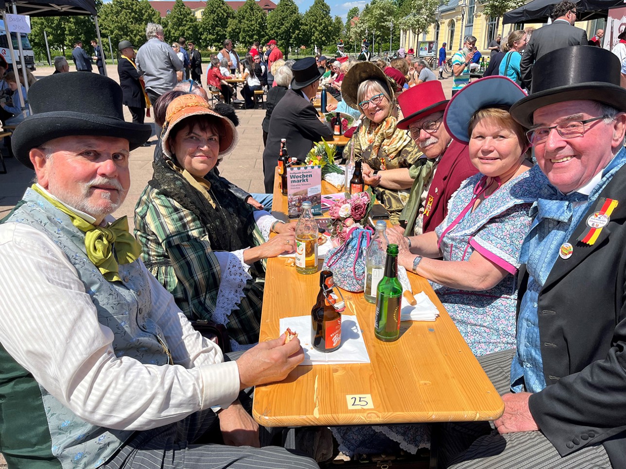 Bei der Reithalle angekommen, gabs eine Erfrischung. Foto: Stadt Rastatt/Heike Bornhäußer Schauspieler sitzen auf einer Bierbank vor der Reithalle