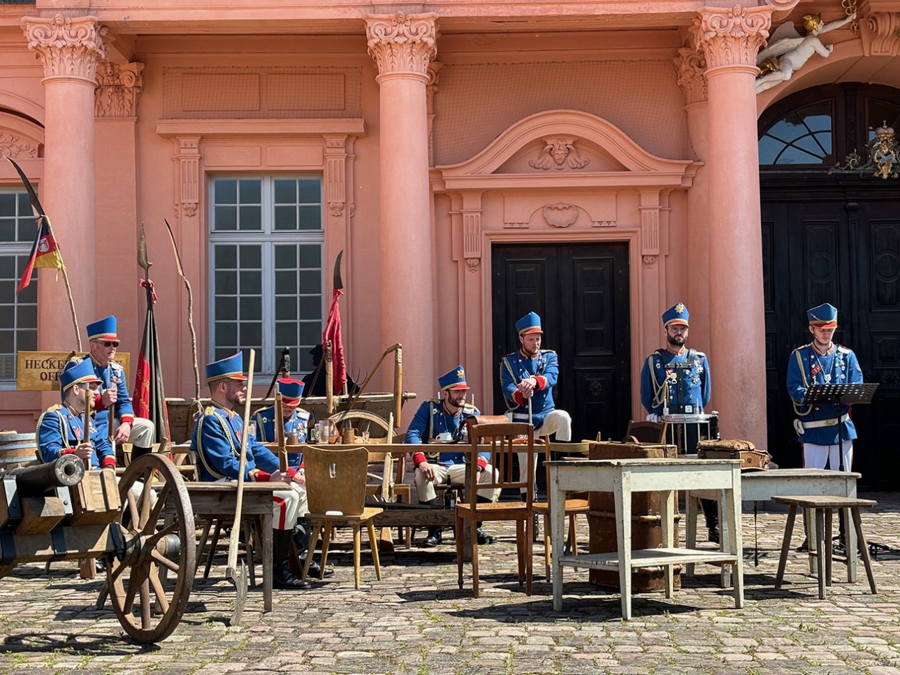 Schauspiel "Zeitreise in die Badische Revolution 1849". Foto: Stadt Rastatt/Isabelle Joyon Soldaten sitzen vor dem Schloss beim Schauspiel "Zeitreise in die Badische Revolution 1849"