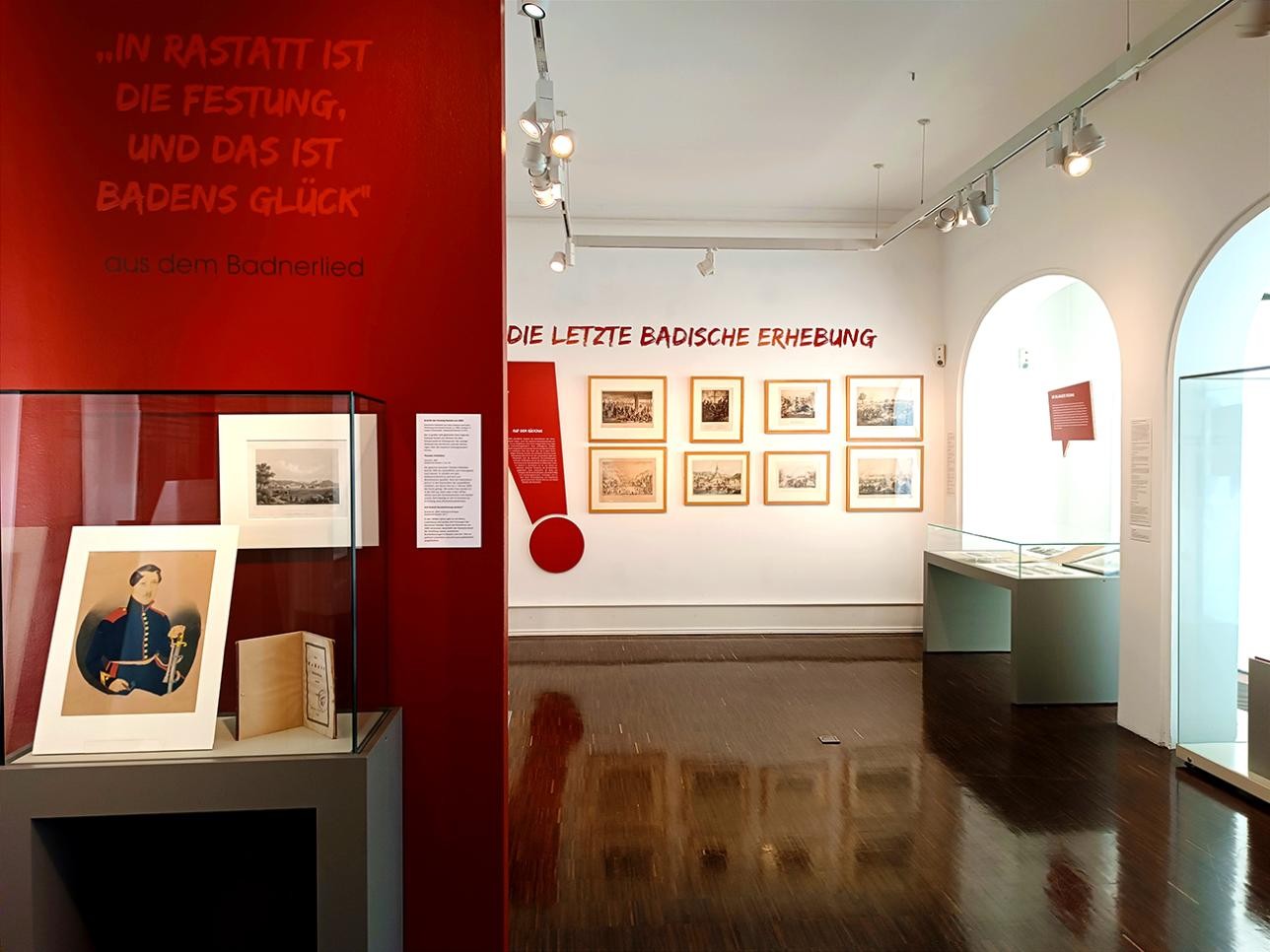 Salle dans le musée de la ville avec une vitrine et des images de l'exposition temporaire : "Pour la liberté ! Rastatt et la révolution 1848/49"