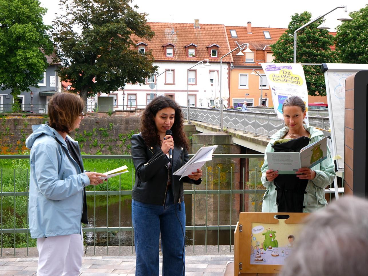 Three women read different stories at the opening