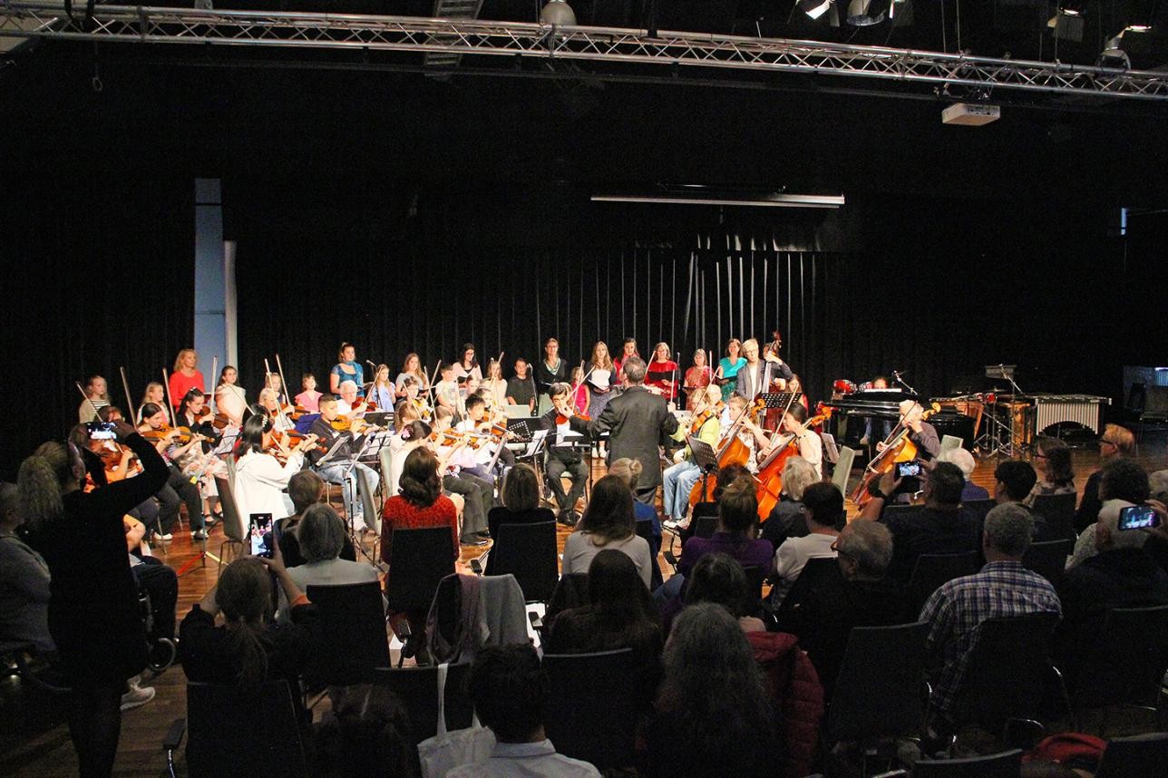 Audience and musicians on stage at the music school's family concert