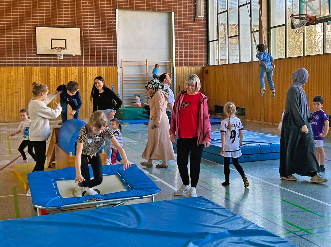 Bewegungsparcours beim Elterntreff des KiFaz BIBER. Foto: Petra Oser/Stadt Rastatt Kinder turnen in einer Sporthalle, Eltern sind mit dabei