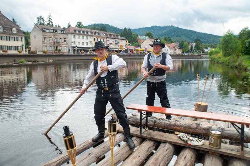 Mitglieder der Gernsbacher Murgflößer e. V. bewahren die Tradition der Holzflößerei (Foto: Europäische Fotoakademie) Zwei Mitglieder des Vereins der Gernsbacher Murgflößer auf einem Holzfloß auf der Murg