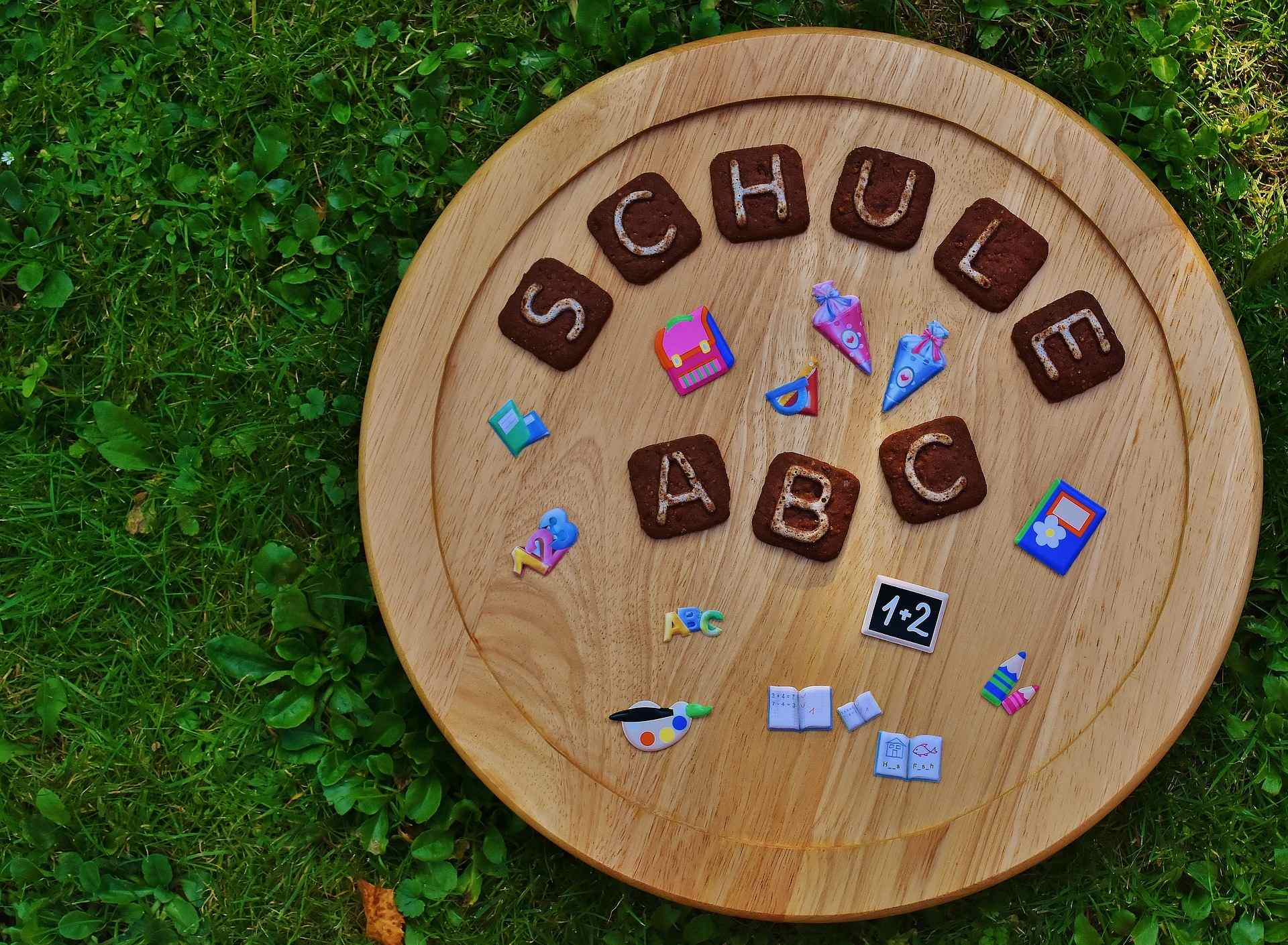 Holzkreis mit Buchstaben und Symbolen, die "Schule - ABC" zeigen