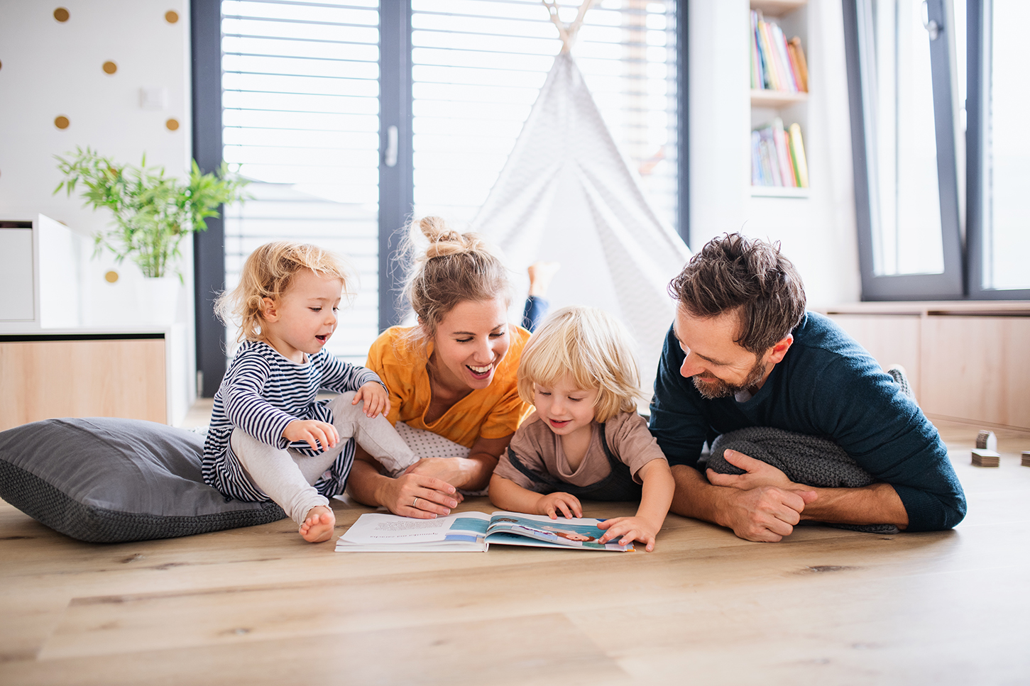 Eltern lesen Kindern ein Buch vor