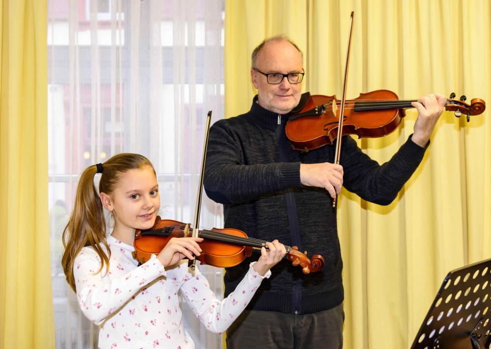 Une jeune fille et un professeur de musique jouent ensemble du violon