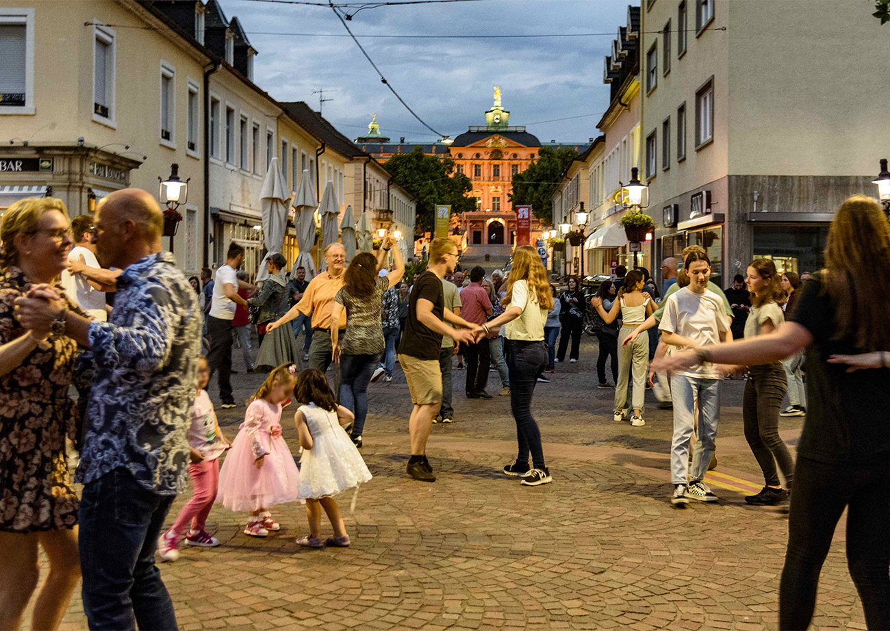 Des gens qui dansent sur la place du marché lors de la danse sous les platanes