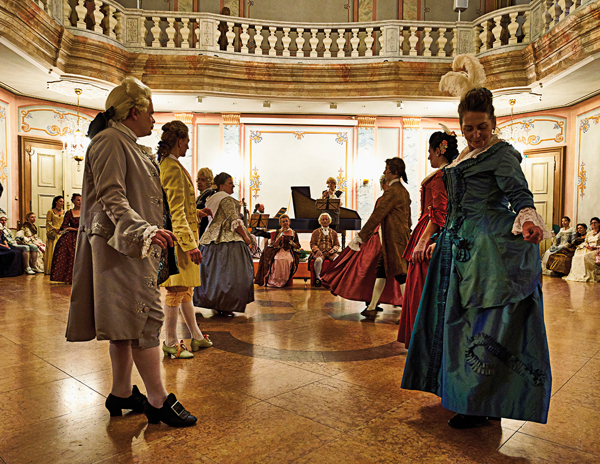 Menschen tanzen in Barockkostümen