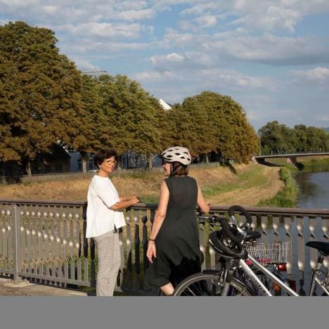 Zwei Frauen auf einer Brücke mit den Fahrräder.